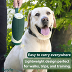 Person holding a green Petifo portable dog water bottle next to a smiling labrador dog during an outdoor walk.