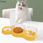 Cute white cat licking its lips next to a yellow Petifo 3-in-1 pet feeder and water dispenser.