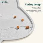 Close-up of a gray silicone pet mat demonstrating its anti-overflow curling design holding spilled kibble and water.