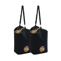 Two black hanging hay feeder bags filled with dry straw on a white background.