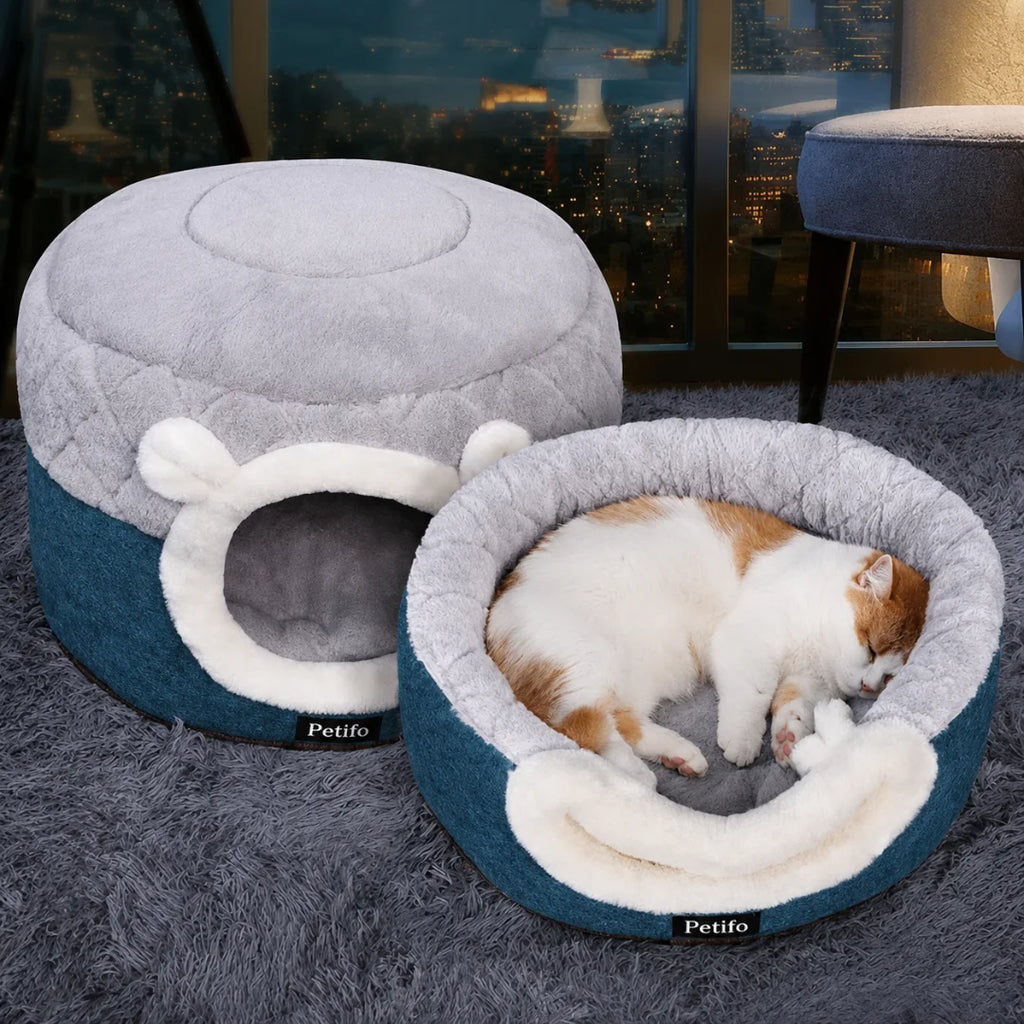 Orange and white cat sleeping in an open Petifo cat bed next to a cave bed