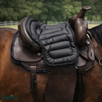Close-up view of a black quilted saddle cushion placed on top of an English leather saddle.