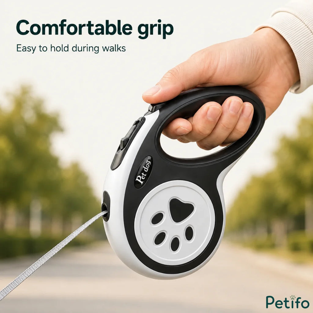 A close-up of a person's hand holding a comfortable ergonomic black and white retractable dog leash.