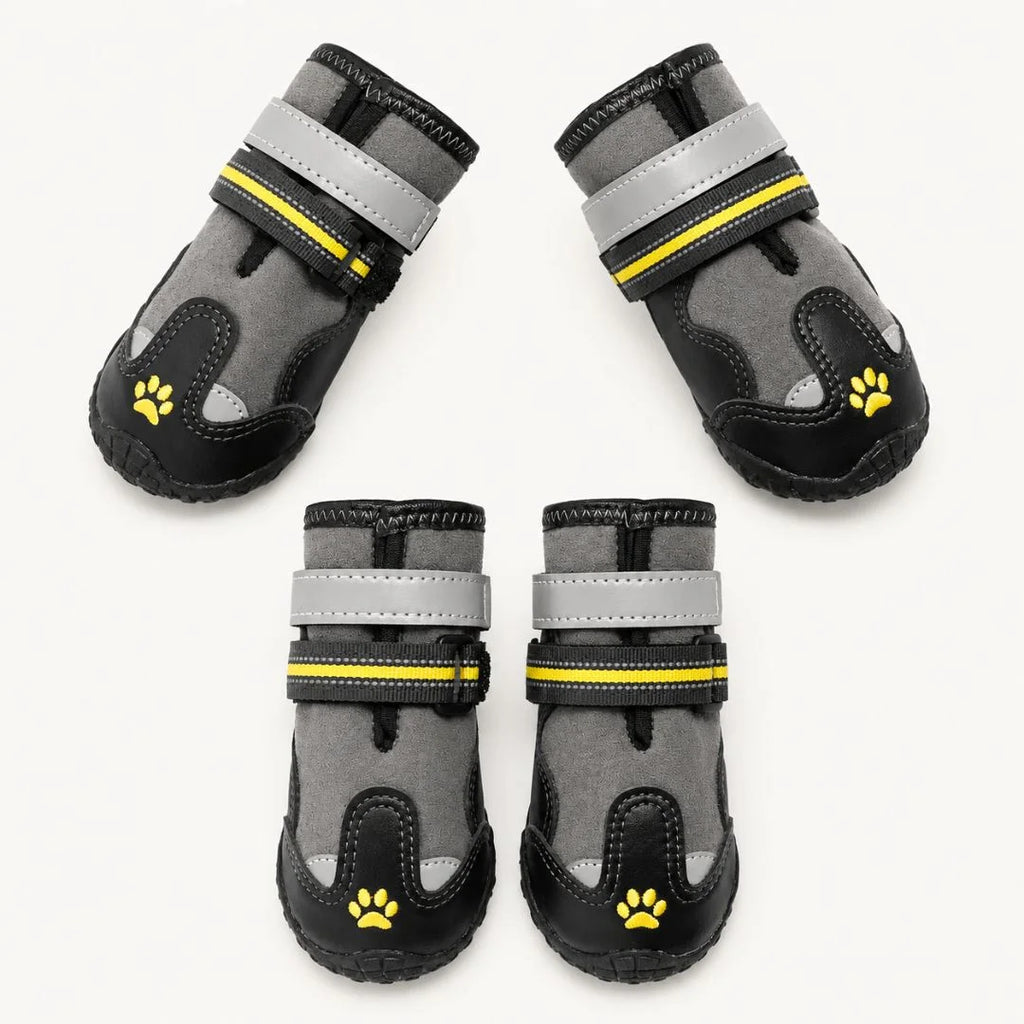 Complete set of four grey and black dog shoes featuring adjustable straps and yellow paw print embroidery on a white background.