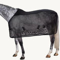 Dappled grey horse standing against a white background while wearing a black fly sheet.