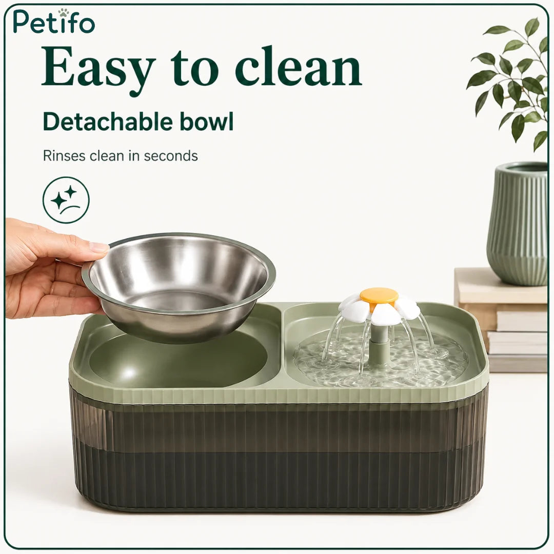 A hand lifting out the detachable stainless steel food bowl from the green pet feeder for fast and easy cleaning.