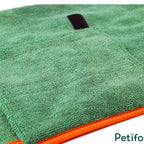 Detailed view of high-absorbency green microfibre material with orange edge binding