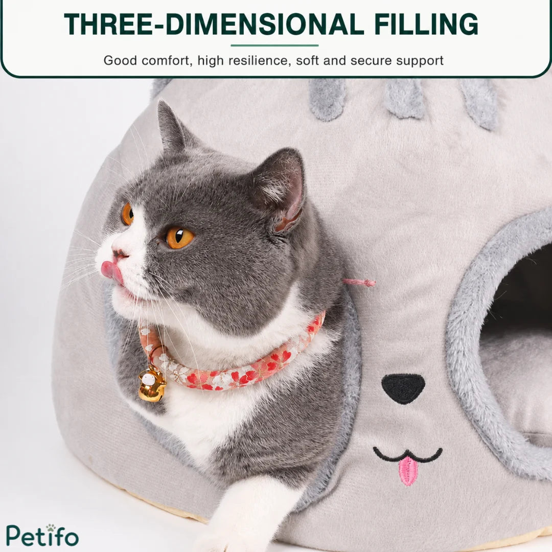 Close-up of a grey cat peeking out from the dual-hole entrance of the Petifo nest, highlighting its three-dimensional filling and secure support.