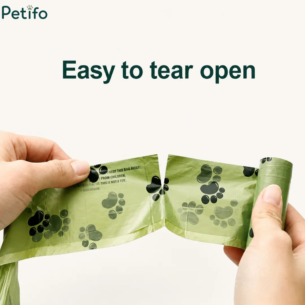 Hands easily tearing apart an eco-friendly green dog waste bag along the perforated seam.