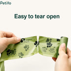 Hands easily tearing apart an eco-friendly green dog waste bag along the perforated seam.