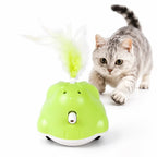 Playful grey tabby cat hunting a green Petifo automated cat toy with a fluffy white feather attachment