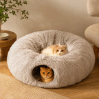 Two adorable cats resting comfortably together inside a plush gray donut cat bed with an integrated tunnel hideout.