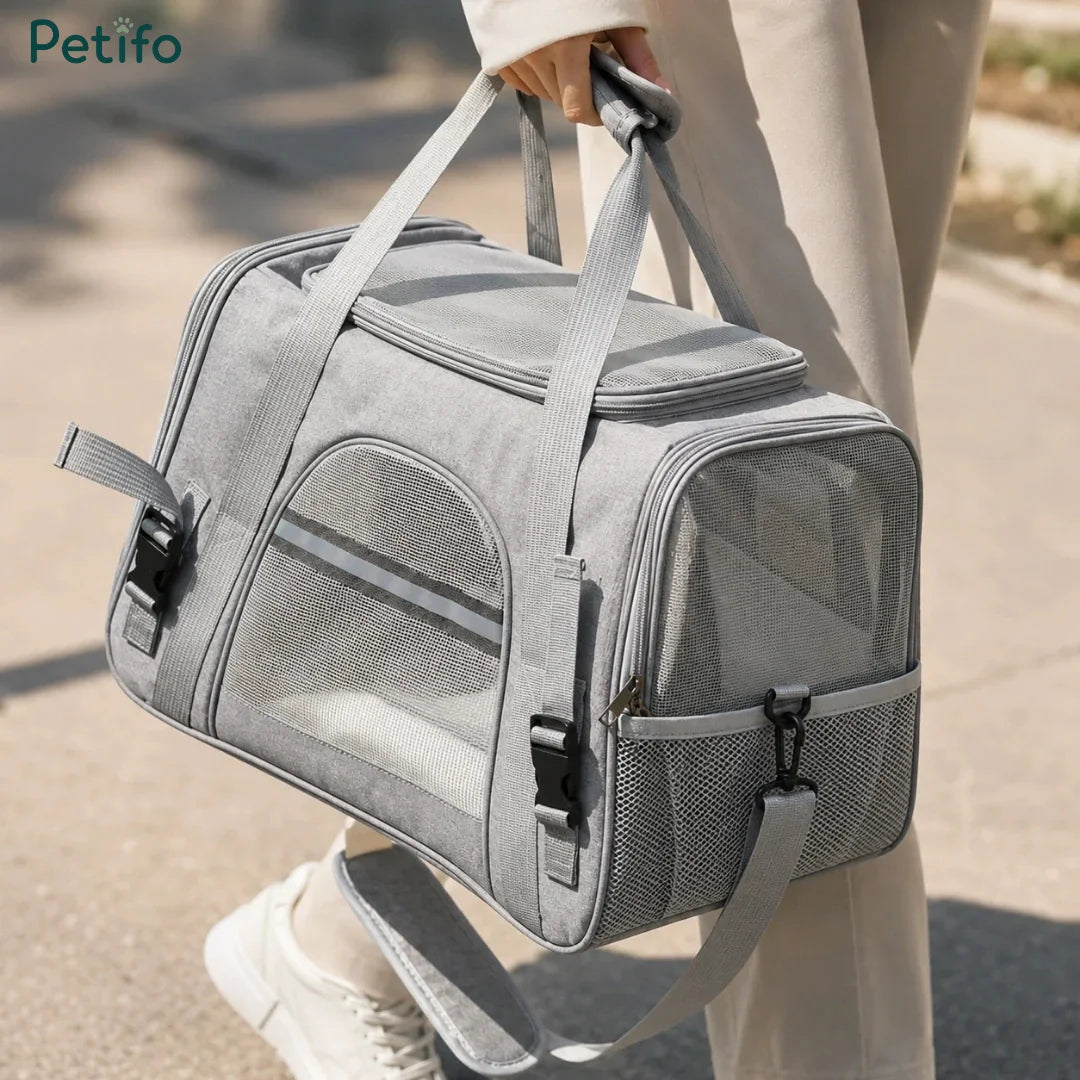 Person carrying a grey Petifo pet travel carrier outdoors.