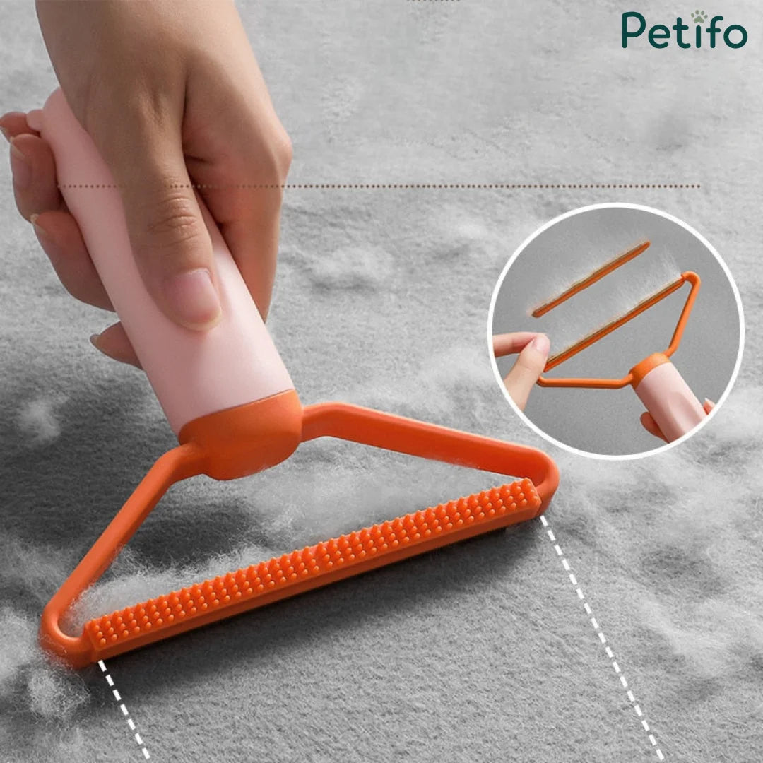 A hand using a peach and orange lint remover tool to clean pet hair off gray fabric, with an inset showing the tool's dual-sided design.