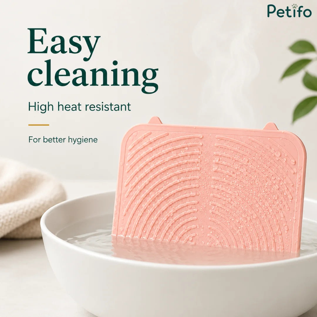Pink Petifo silicone lick mat being cleaned in a bowl of warm water for high hygiene