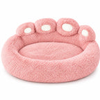 Standalone pink plush paw-shaped dog bed displayed on a clean white background.