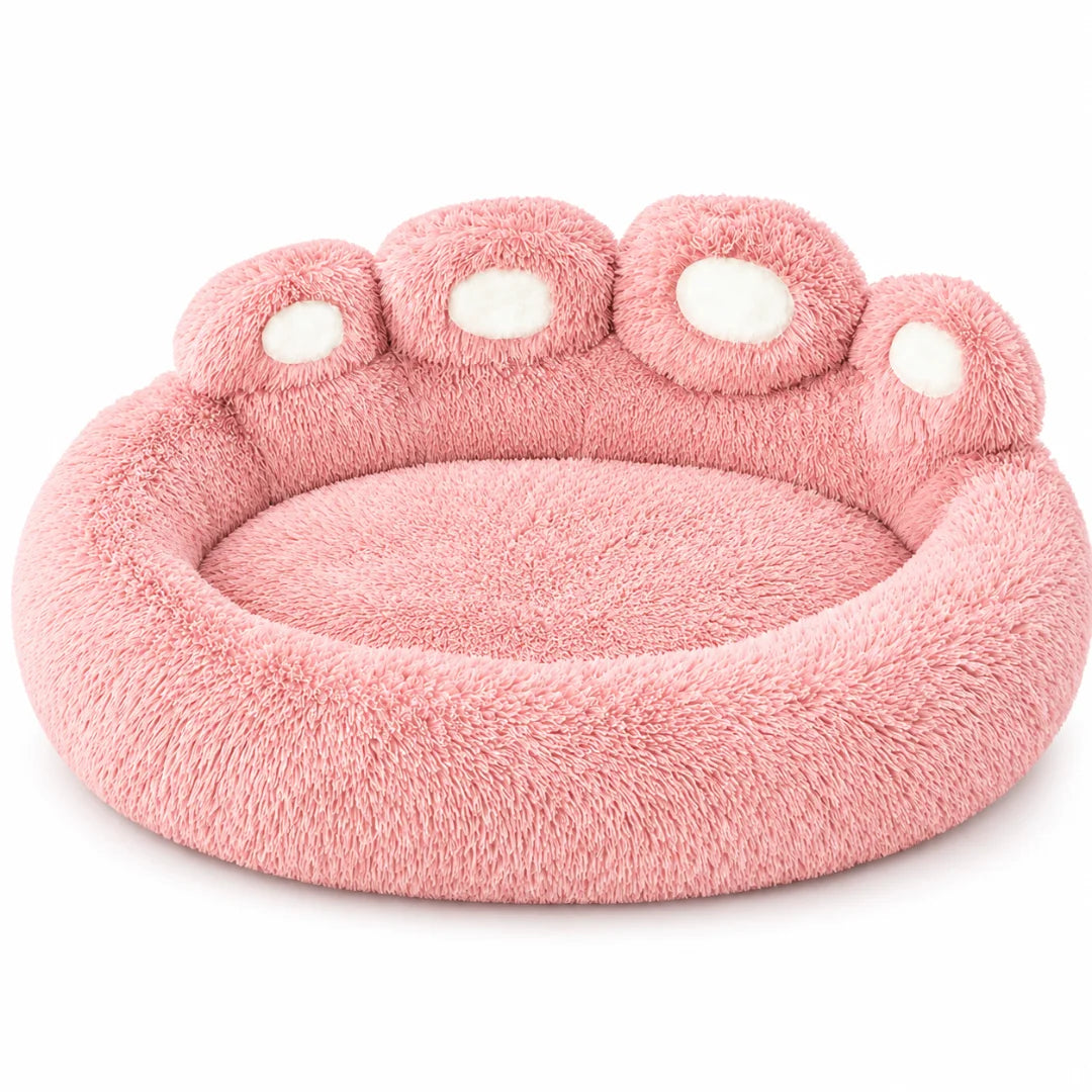 Standalone pink plush paw-shaped dog bed displayed on a clean white background.