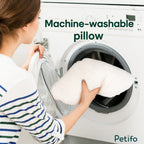 A person placing a soft white plush pet bed cushion into a washing machine for easy cleaning.