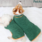 Top view of two dogs wearing green quick-dry towel coats with orange trim