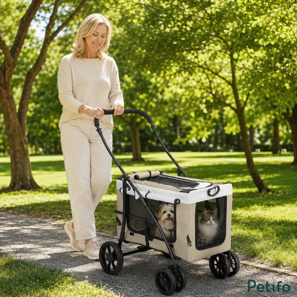 Woman walking along a sunny park pathway while pushing the Petifo beige multi-pet stroller carrying a small dog and cat.